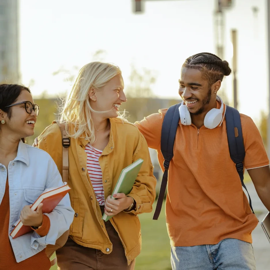 A group of college students with books walking and smiling.