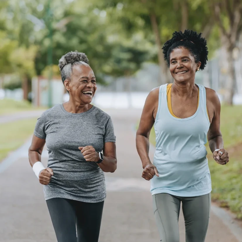 Women walking together for exercise and smiling.
